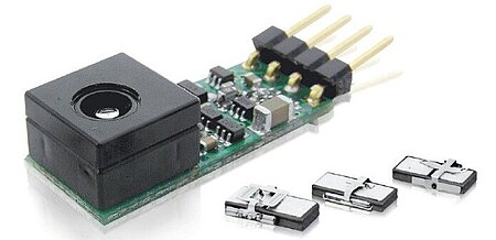 Miniature autofocus lens / driver on a small PCB shown with compact piezo linear motors